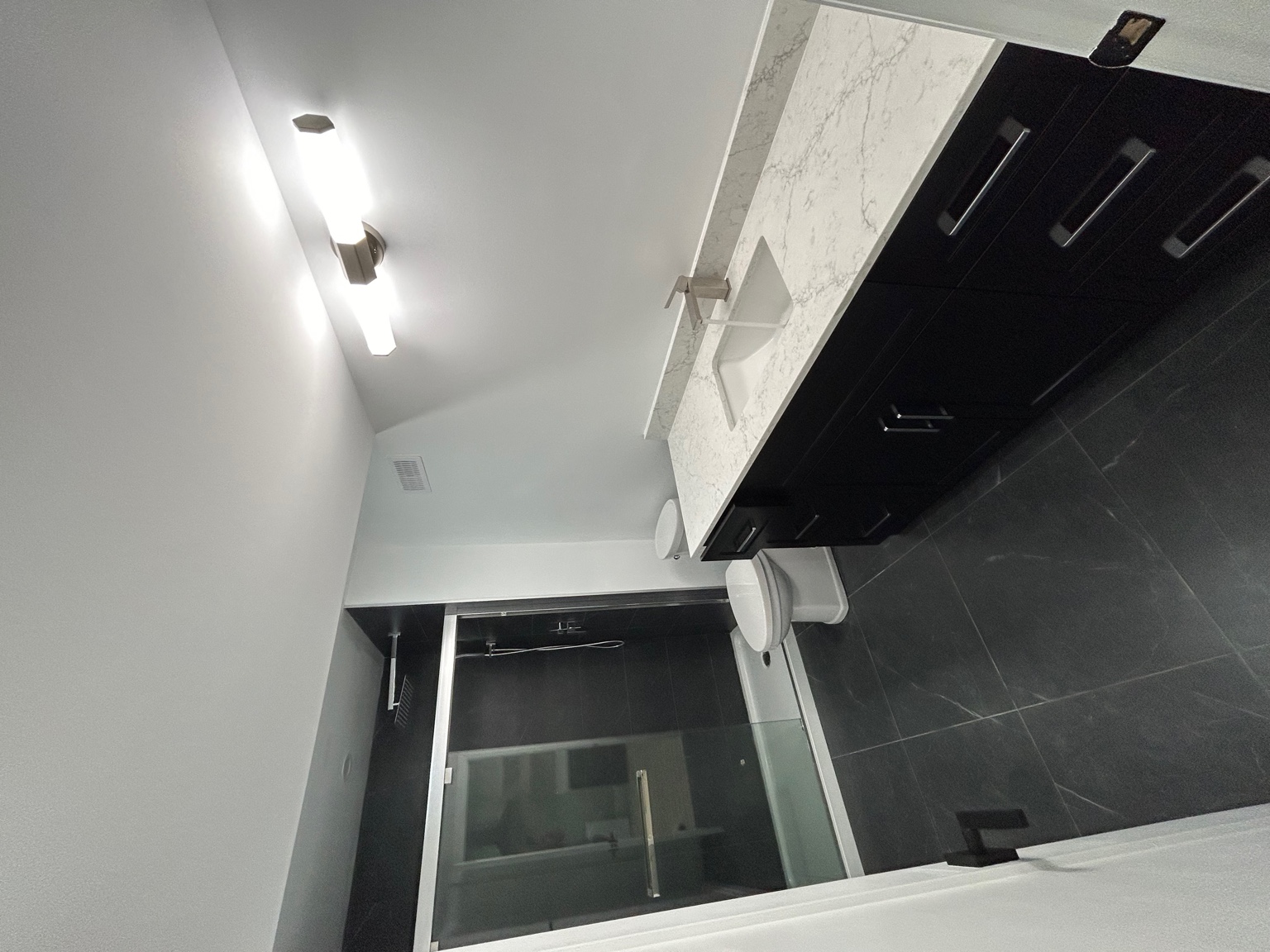 Black tile bathroom with quartz vanity