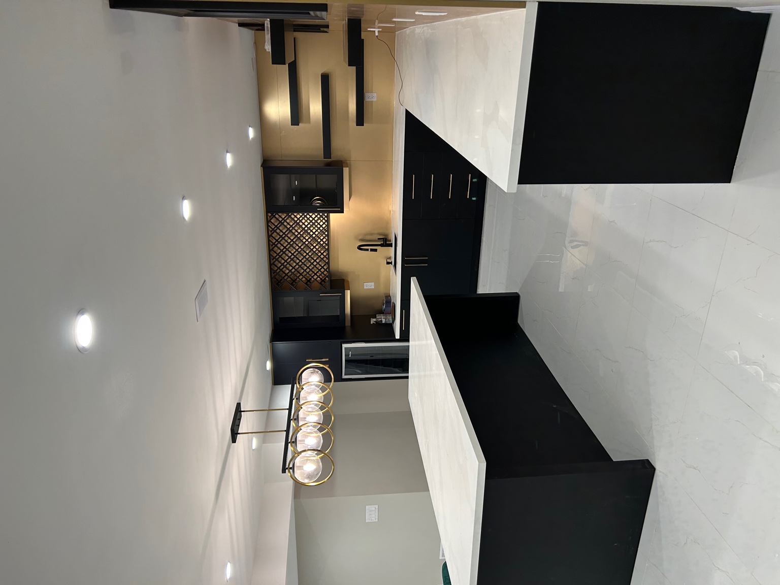 Modern kitchen renovation with dark cabinetry and gold accents